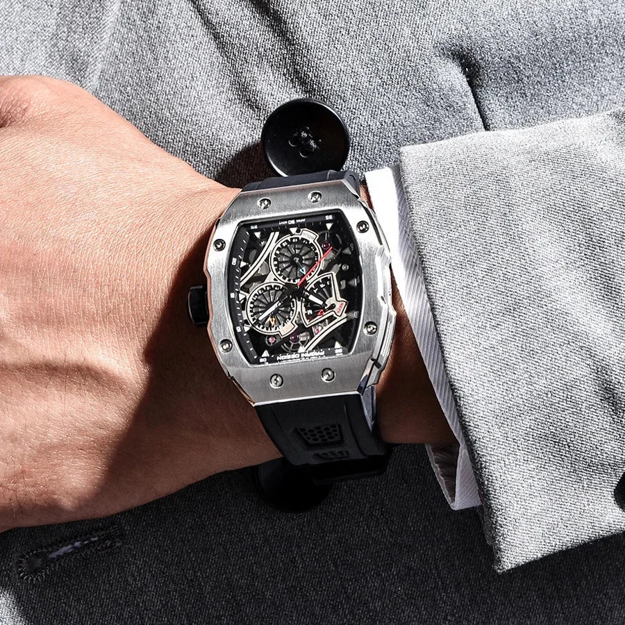 Wrist shot of Pagani Design PD‑YS012 skeleton sport watch with black rubber strap and silver tonneau case worn on a person’s wrist with a gray suit jacket, showcasing the skeleton dial and chronograph subdials.
