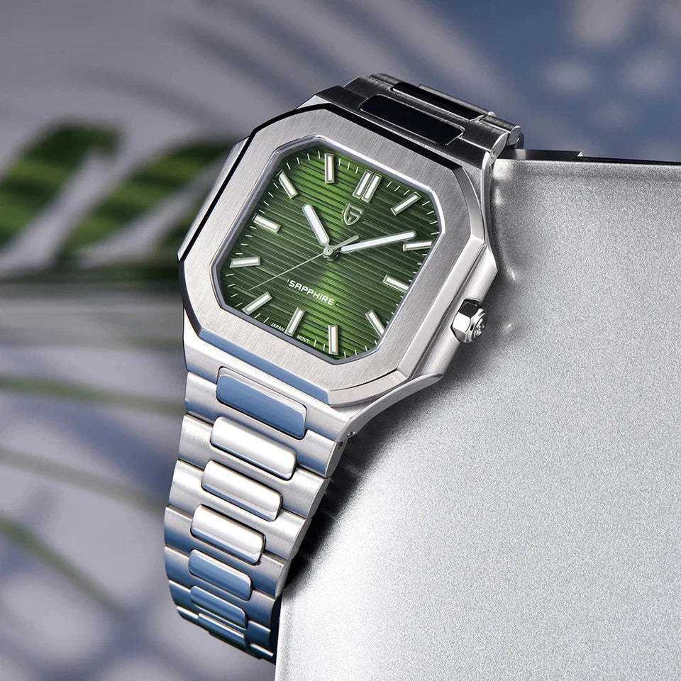 Lifestyle photo of Pagani Design PD-YS019 square quartz watch with green dial and stainless steel bracelet resting on a stone surface with blurred plant background.
