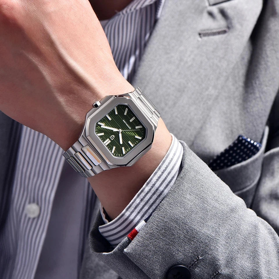 Wrist shot of Pagani Design PD-YS019 square quartz watch with green dial and stainless steel bracelet, worn with a grey suit, showcasing the watch on the wrist.