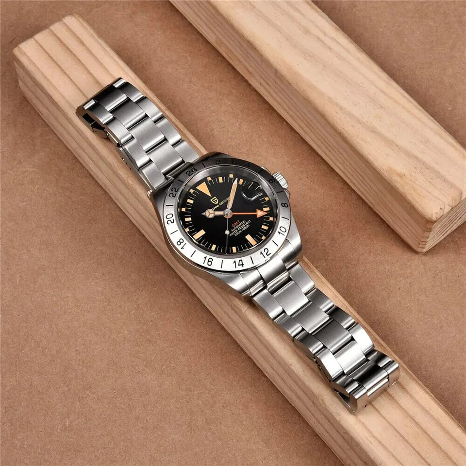 Pagani Design PD-1693 men's luxury automatic GMT watch with black dial and silver bracelet on wooden surface
