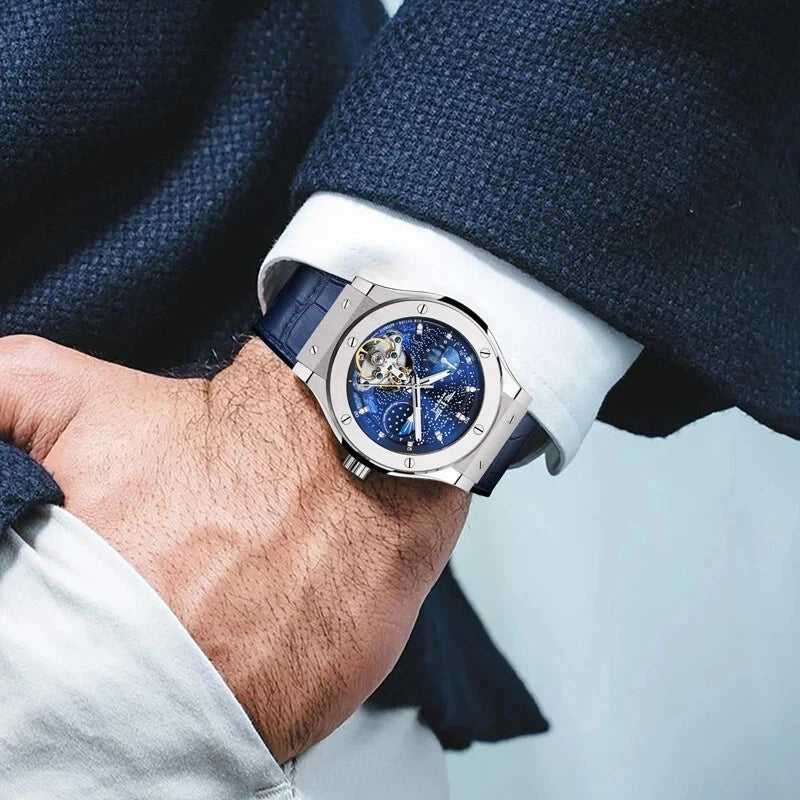 Wrist shot of PINDU Design 6537 automatic mechanical watch featuring moonphase and skeleton tourbillon, stainless steel case, blue leather strap, worn with suit