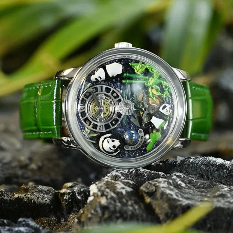 Pindu M27 mechanical watch with rotating crystal ball and skeleton dial, stainless steel case and green leather strap, photographed outdoors on a rock with foliage