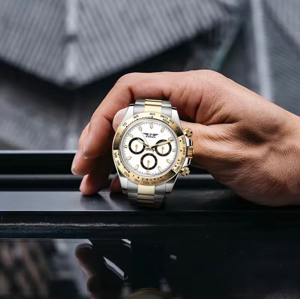 PINDU P6589 white dial two-tone chronograph held in hand on a rooftop railing