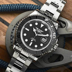 PINDU PD6510 GMT automatic watch with black dial and steel bracelet on nautical wood backdrop
