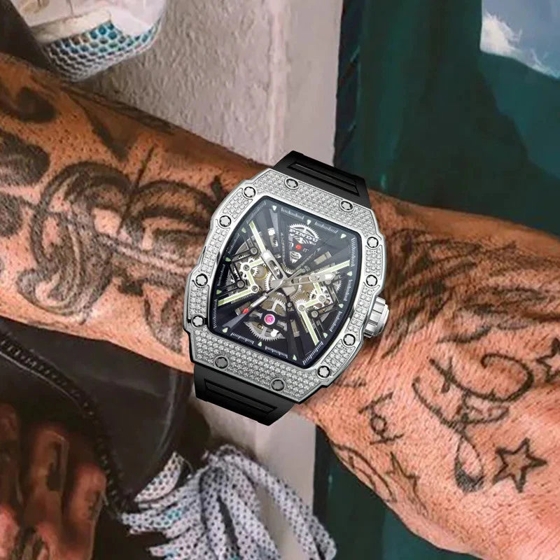 Wrist shot of Pindu PD6550 wine barrel mechanical watch on a tattooed arm featuring skeleton dial, diamond-set bezel, stainless steel case, and black silicone strap.