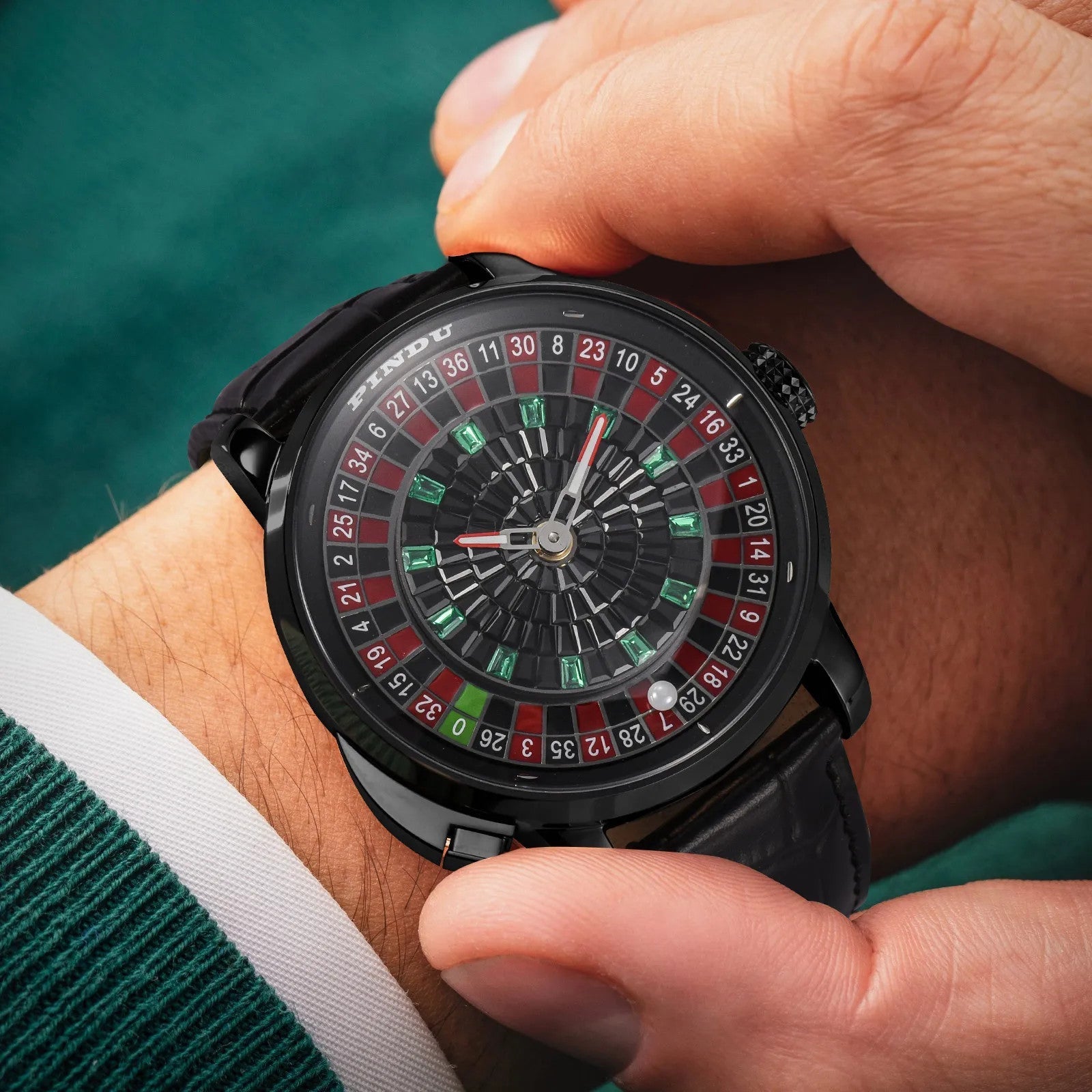PINDU PD6628 Roulette watch with black case and red green dial on wrist over poker felt
