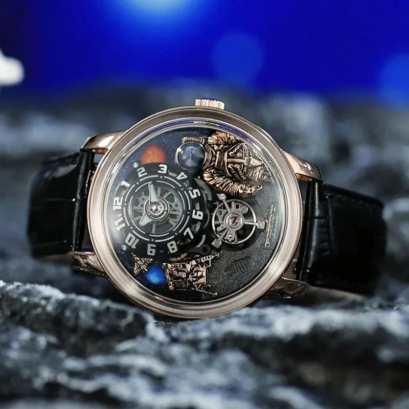 Pindu W2101B Space Series mechanical watch with three-dimensional astronaut and planet motif dial, rose gold case, black leather strap, photographed on a rocky surface with blue blurred background.