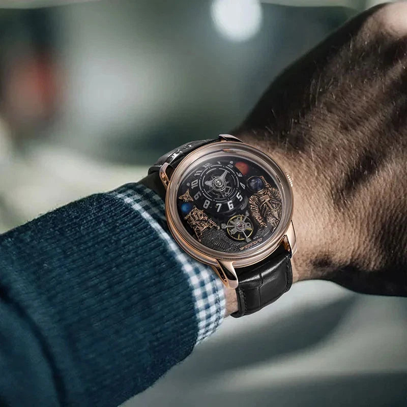 Side view wrist shot of Pindu W2101B Space Series mechanical watch featuring a three-dimensional astronaut and planet motif dial, rose gold case, black leather strap, and mechanical movement, worn with a blue plaid shirt sleeve.