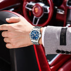 POEDAGAR 834 mens chronograph with blue dial and steel bracelet on wrist with Porsche steering wheel