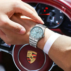 POEDAGAR 839 mens quartz waterproof with ice blue dial and steel jubilee bracelet on wrist driving Porsche