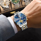 POEDAGAR 938 chronograph watch with blue dial and two-tone bracelet on wrist near watch display case