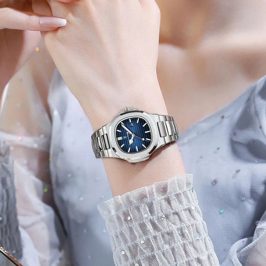 POEDAGAR women's quartz watch with blue dial and steel bracelet on wrist with styled blouse