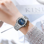 POEDAGAR women's quartz watch with blue dial and steel bracelet on wrist with sheer sleeve