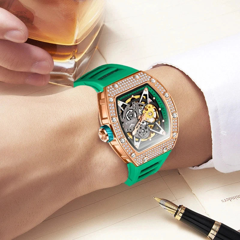 Luxury watch with green strap on wrist, person holding a glass of whiskey, fountain pen on surface