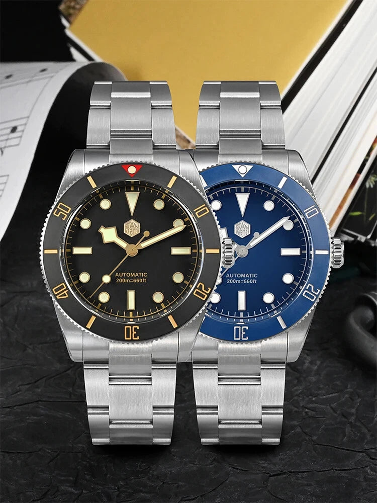 Two silver wristwatches with black and blue faces on a textured surface.