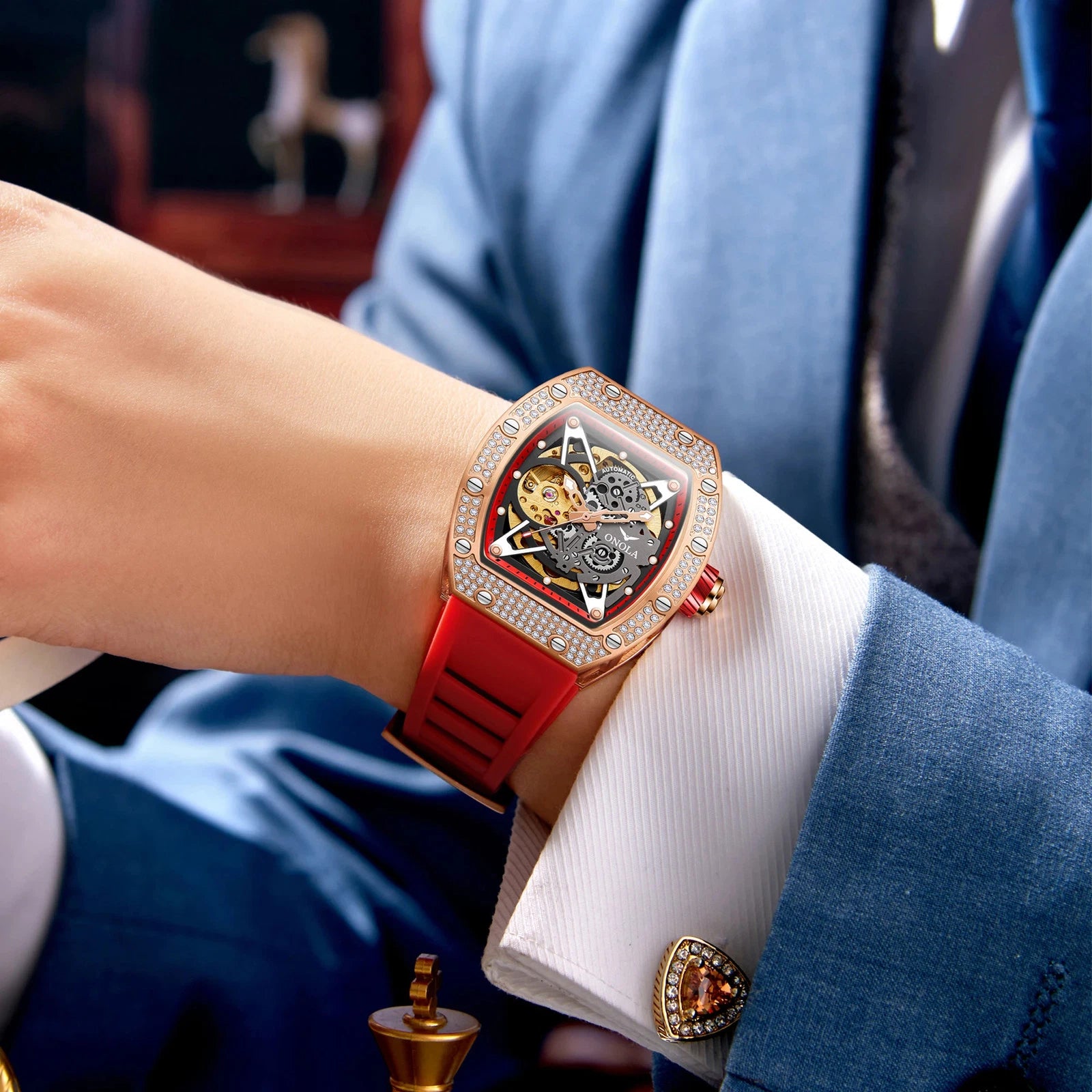 Luxury watch with red strap and intricate design on a person's wrist.