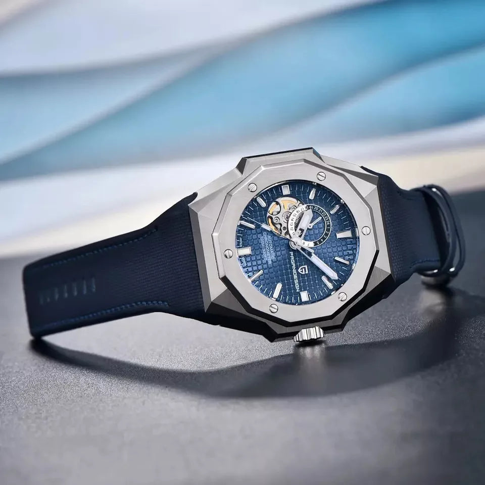 Luxury watch with blue face and black strap on a reflective surface