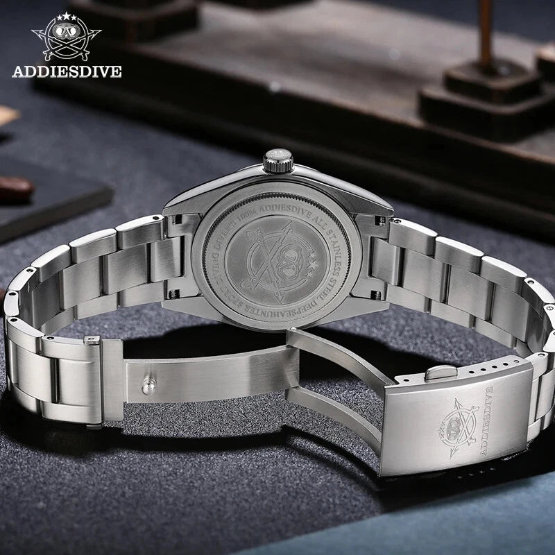 Silver wristwatch with detailed back design on a dark surface, featuring ADDIESDIVE branding.