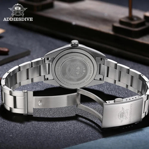 Silver wristwatch with detailed back design on a dark surface, featuring ADDIESDIVE branding.