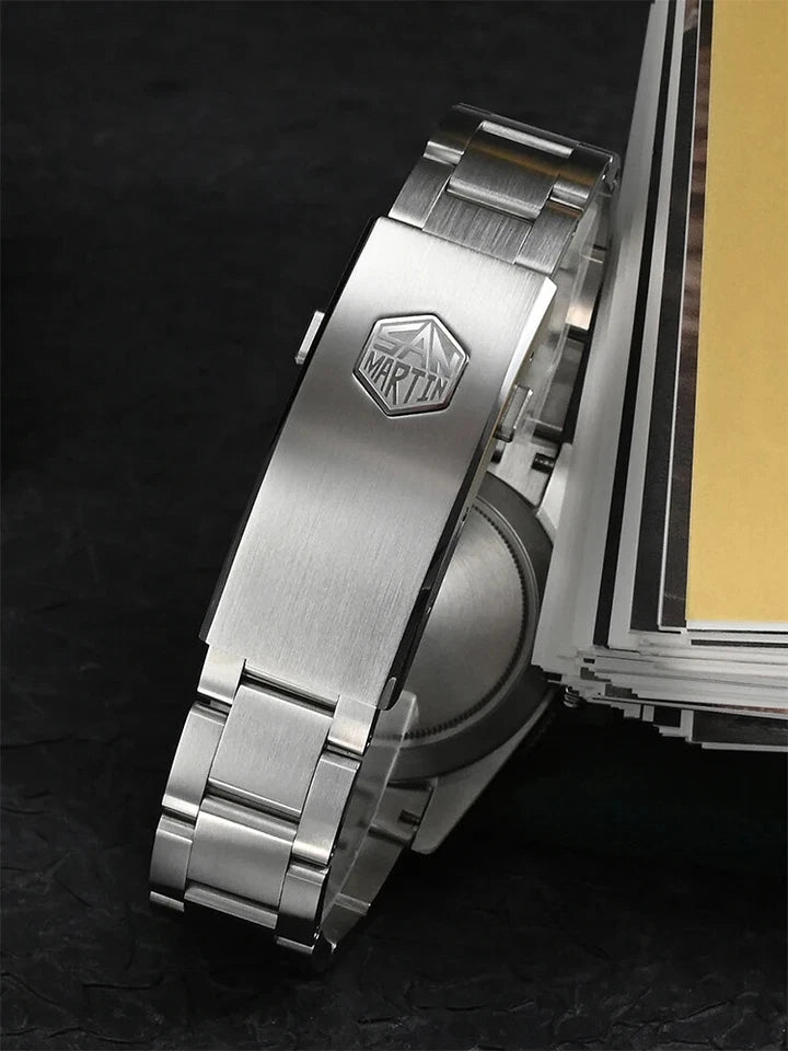 Close-up of a silver watch with a brand logo on a dark background