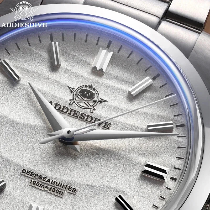 Close-up of a silver watch with 'ADDIESDIVE' branding on a light background