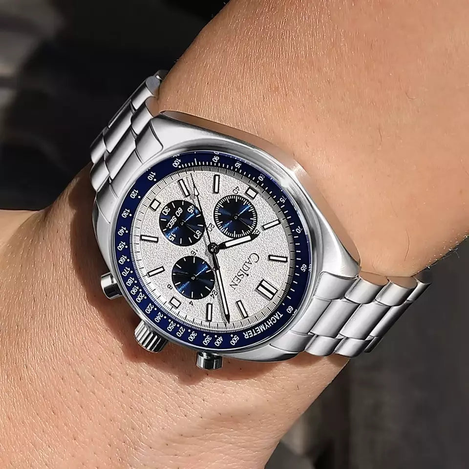 Silver watch with blue accents on a wrist against a neutral background