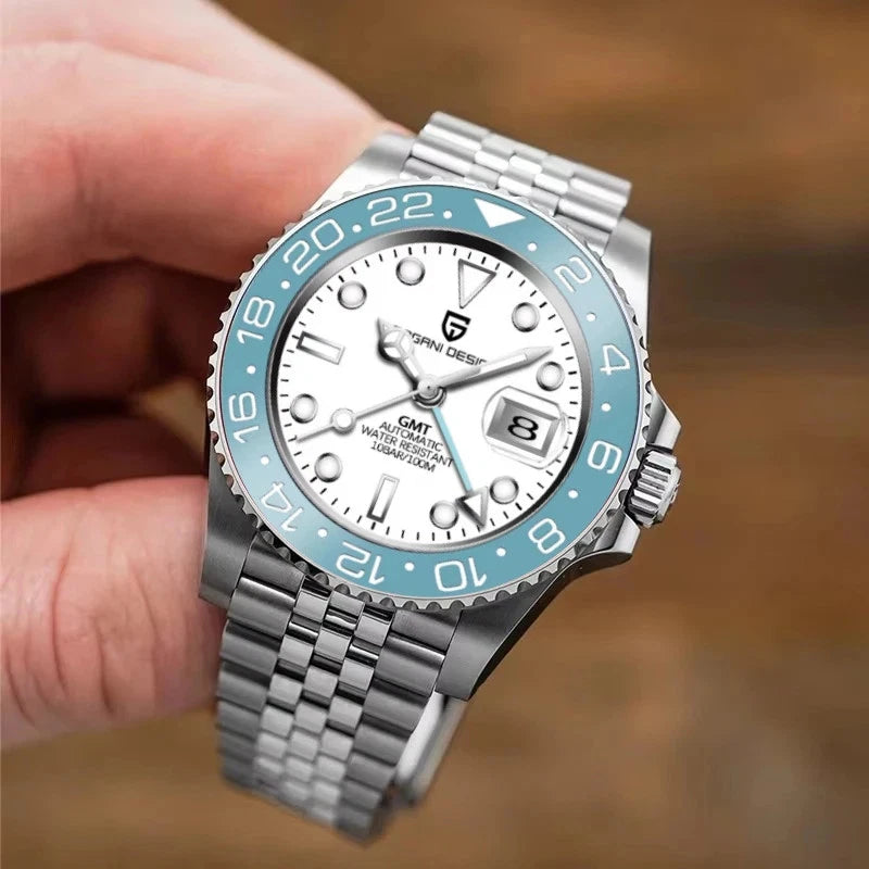Silver watch with blue bezel held by a hand against a blurred background