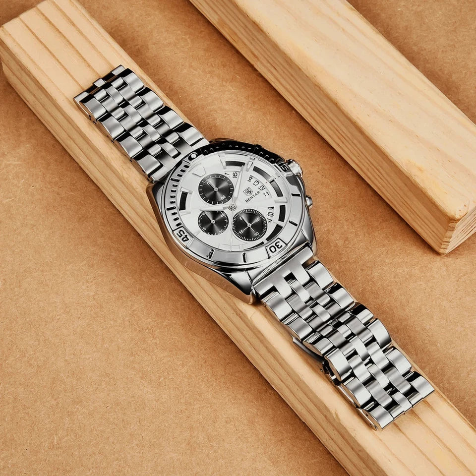 Silver watch with a detailed face on a wooden surface