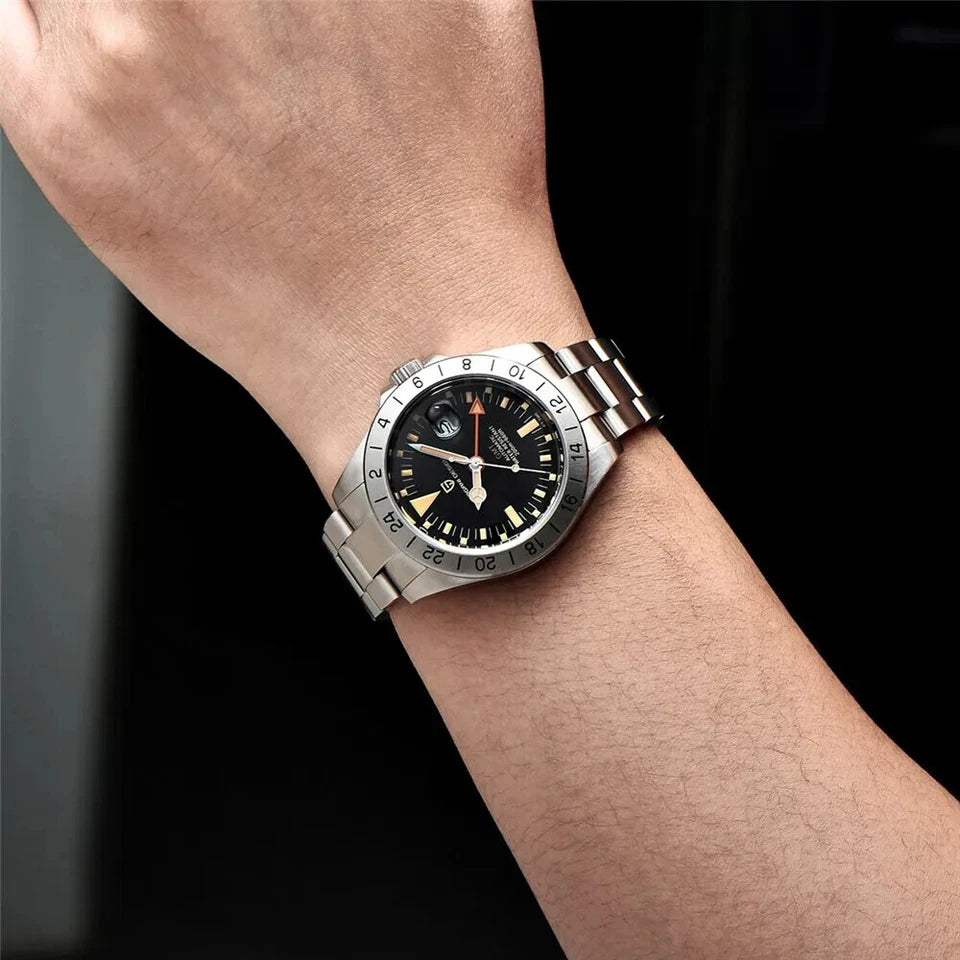 Silver watch with a black face on a wrist against a dark background