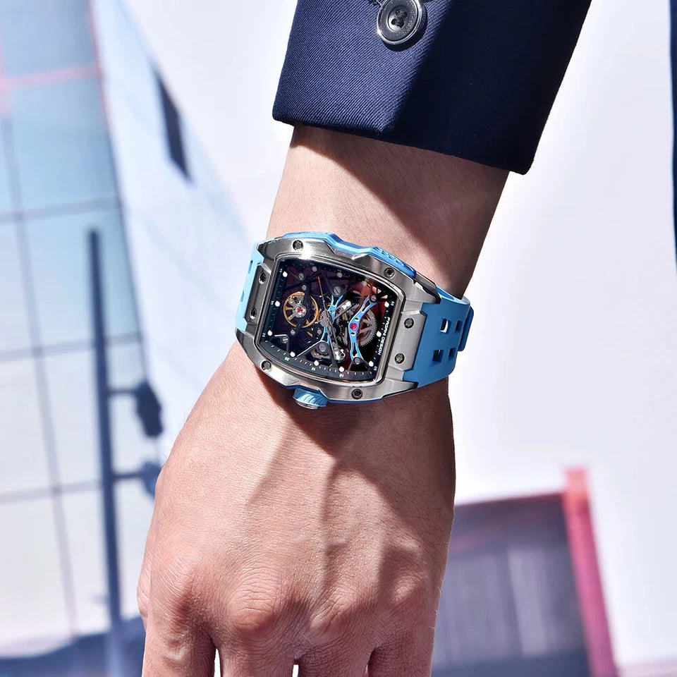 Luxury watch with a blue and silver strap on a person's wrist, blurred background