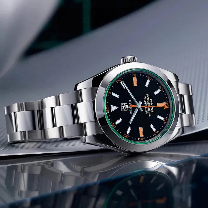 Silver wristwatch with black dial and orange accents on a reflective surface