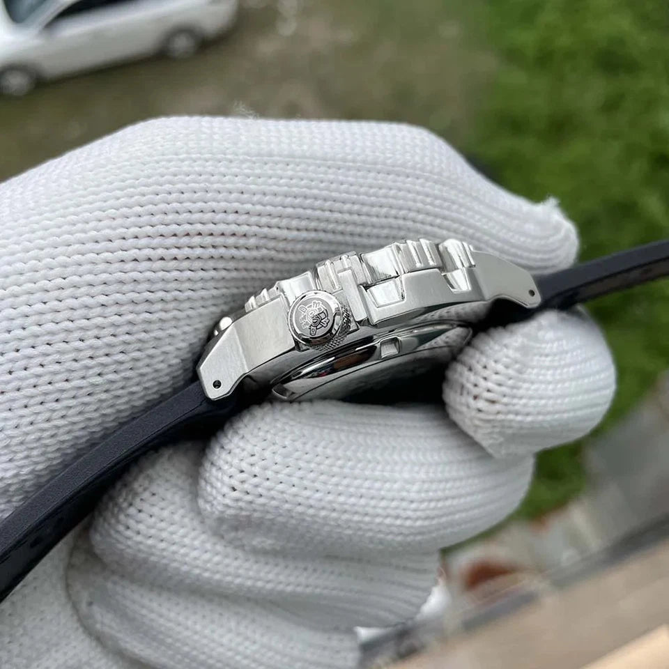 Close-up of a silver watch with a black strap held by a gloved hand.