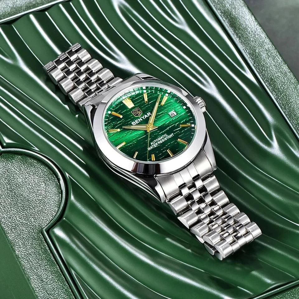 Silver watch with a green face on a green textured background