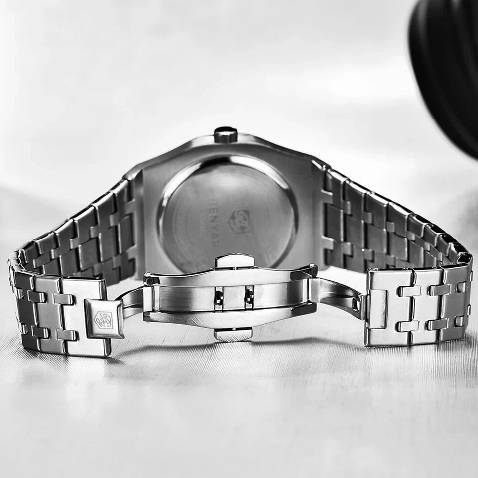 Close-up of a silver watch with a detailed metal band on a light gray background