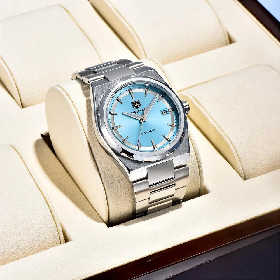 Silver watch with a blue face on a beige cushion