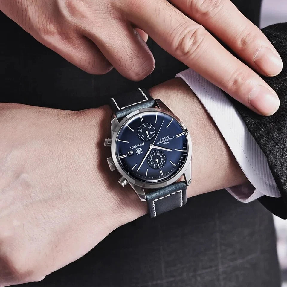 Close-up of a person wearing a wristwatch with a blue face and black strap.