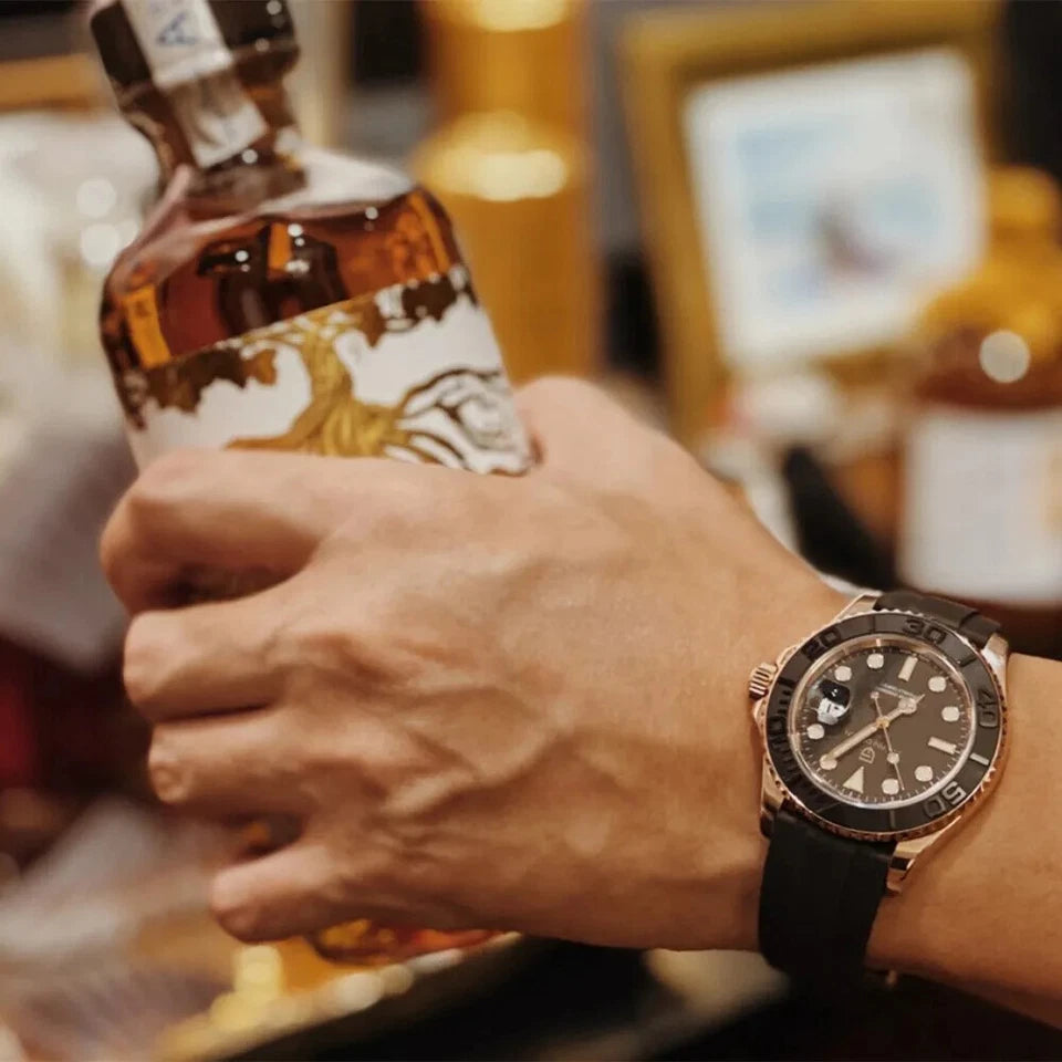 Hand holding a bottle of whiskey with a watch on a blurred background