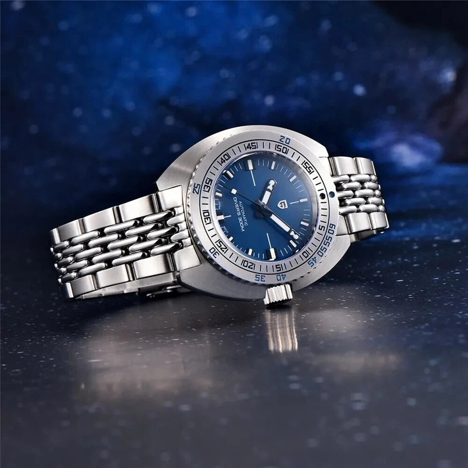 Silver watch with blue dial on a reflective surface with a dark blue gradient background