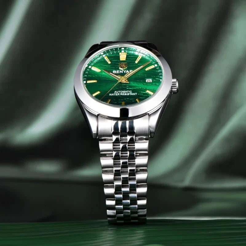 Silver watch with a green face on a green fabric background