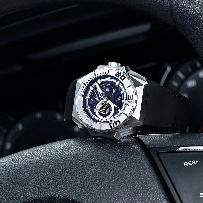 Luxury watch with blue face and silver case on a car dashboard