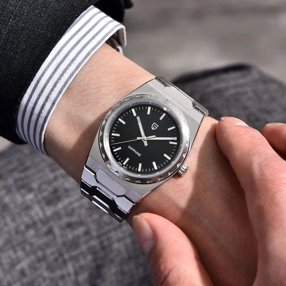 Close-up of a wrist wearing a silver watch with a black face.