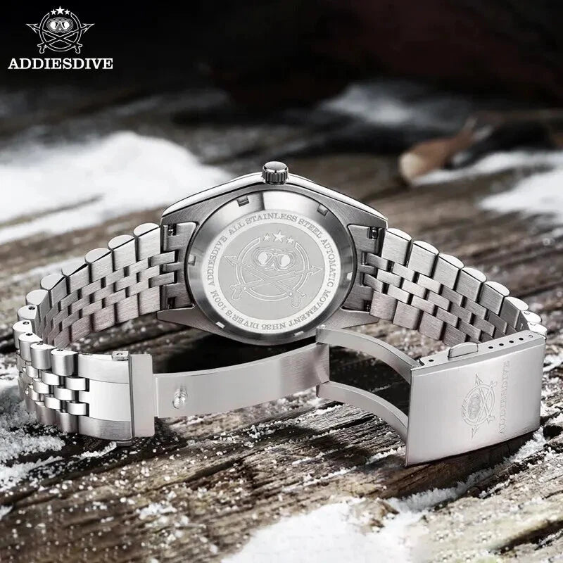 Silver watch with detailed engraving on a wooden surface with snow in the background, featuring the ADDIESDIVE brand.