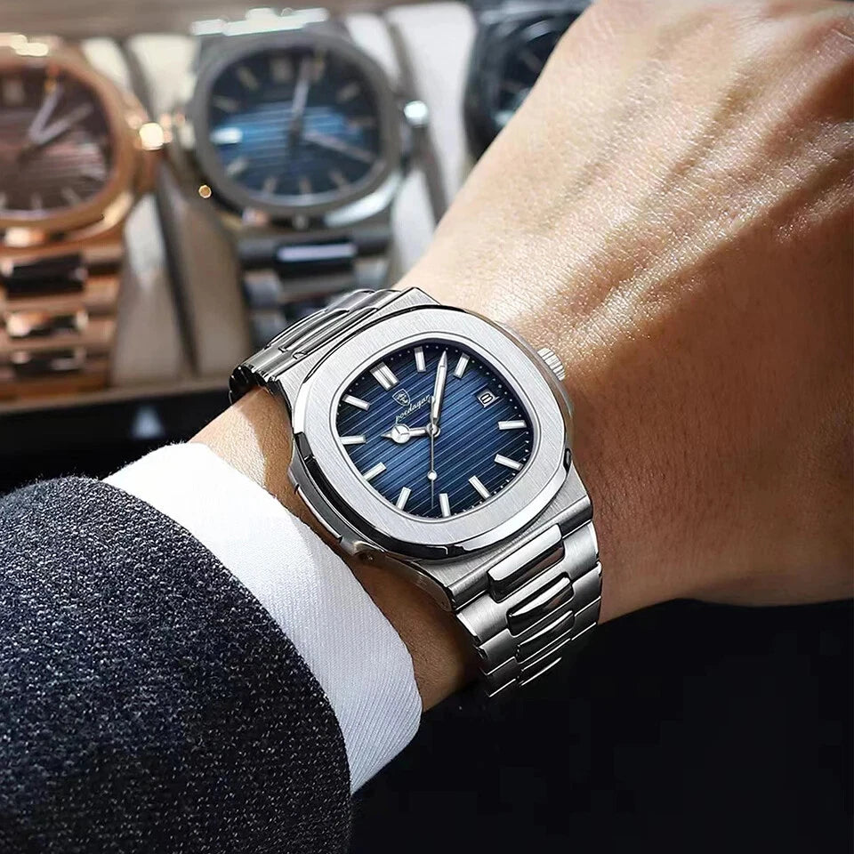 Silver watch with blue face on a person's wrist, with blurred watches in the background