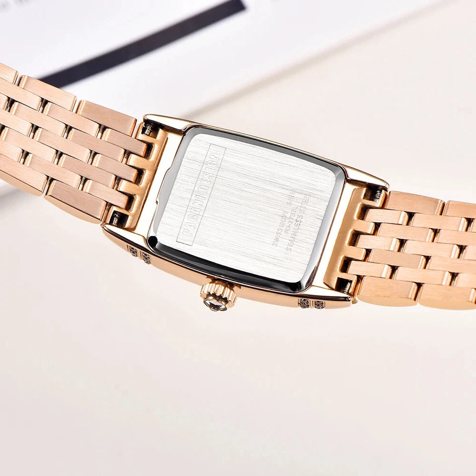 Rose gold watch with a square face on a light background
