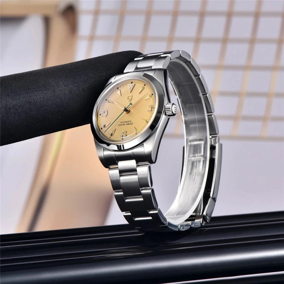 Silver watch with a gold face on a reflective surface