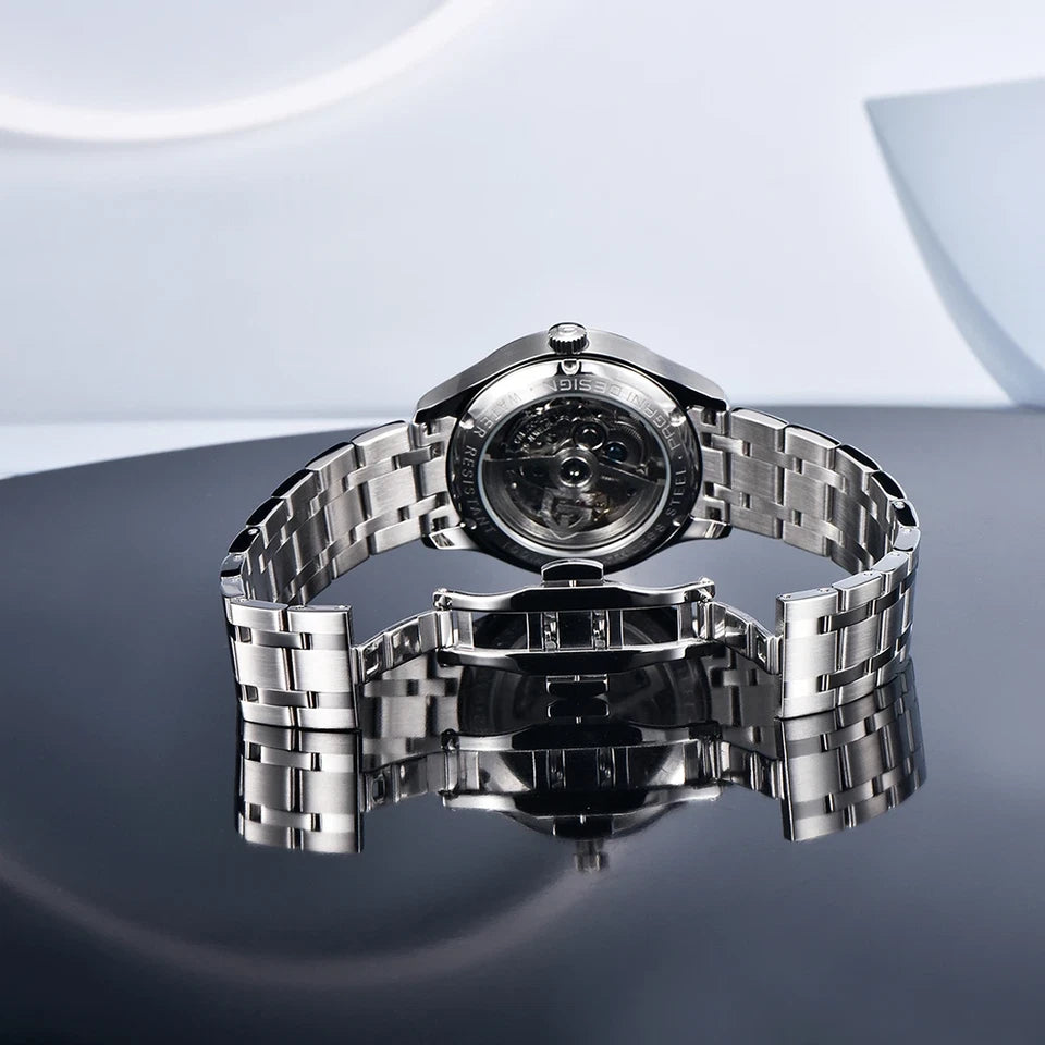 Silver watch with a reflective surface on a gray background