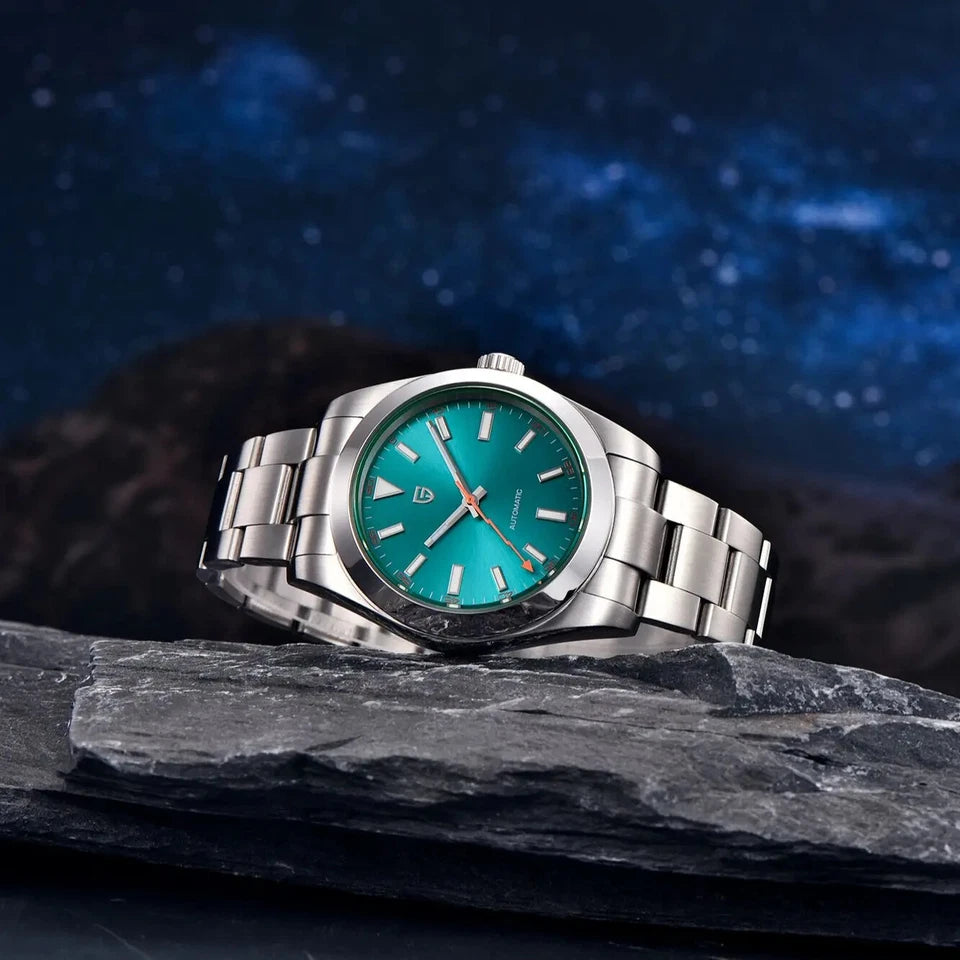 Silver watch with a teal face on a dark rock with a starry night sky background