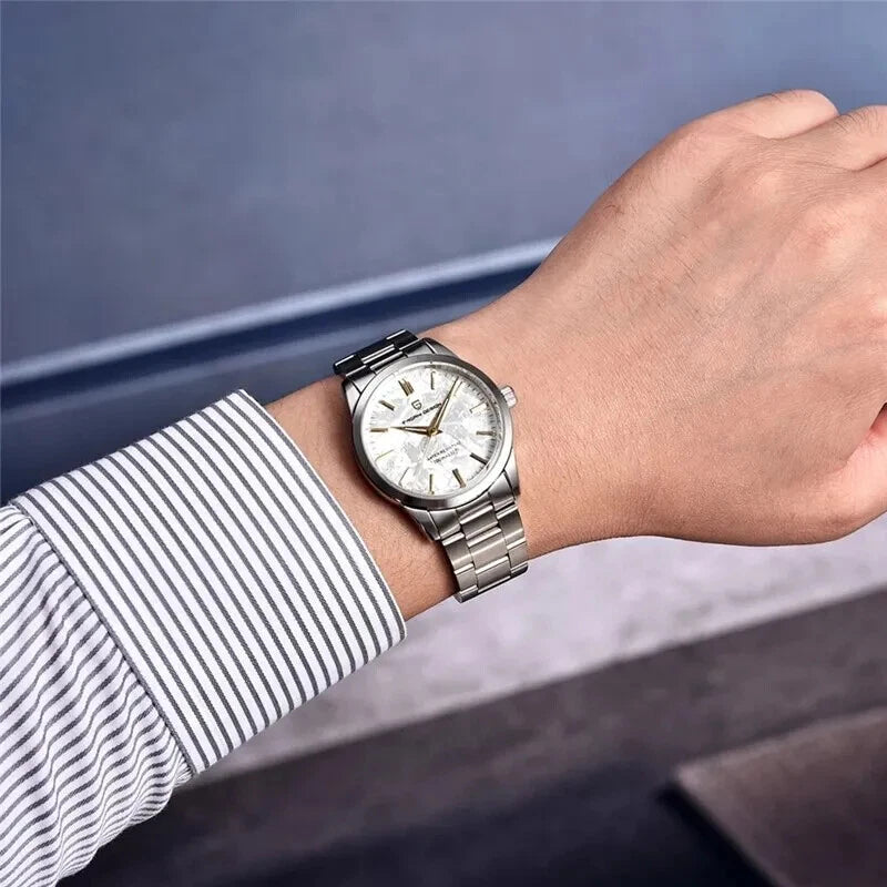 Silver wristwatch on a person's wrist with a blurred background