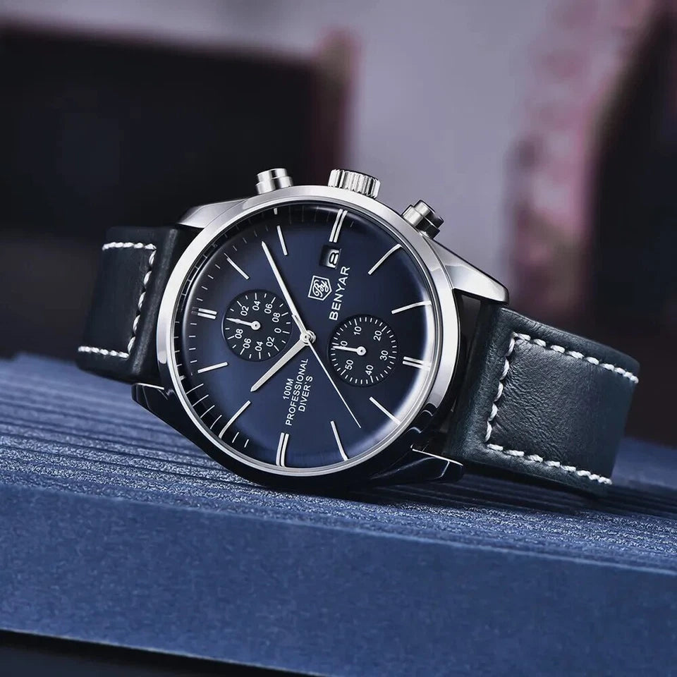 Wristwatch with blue face and black leather strap on a textured surface