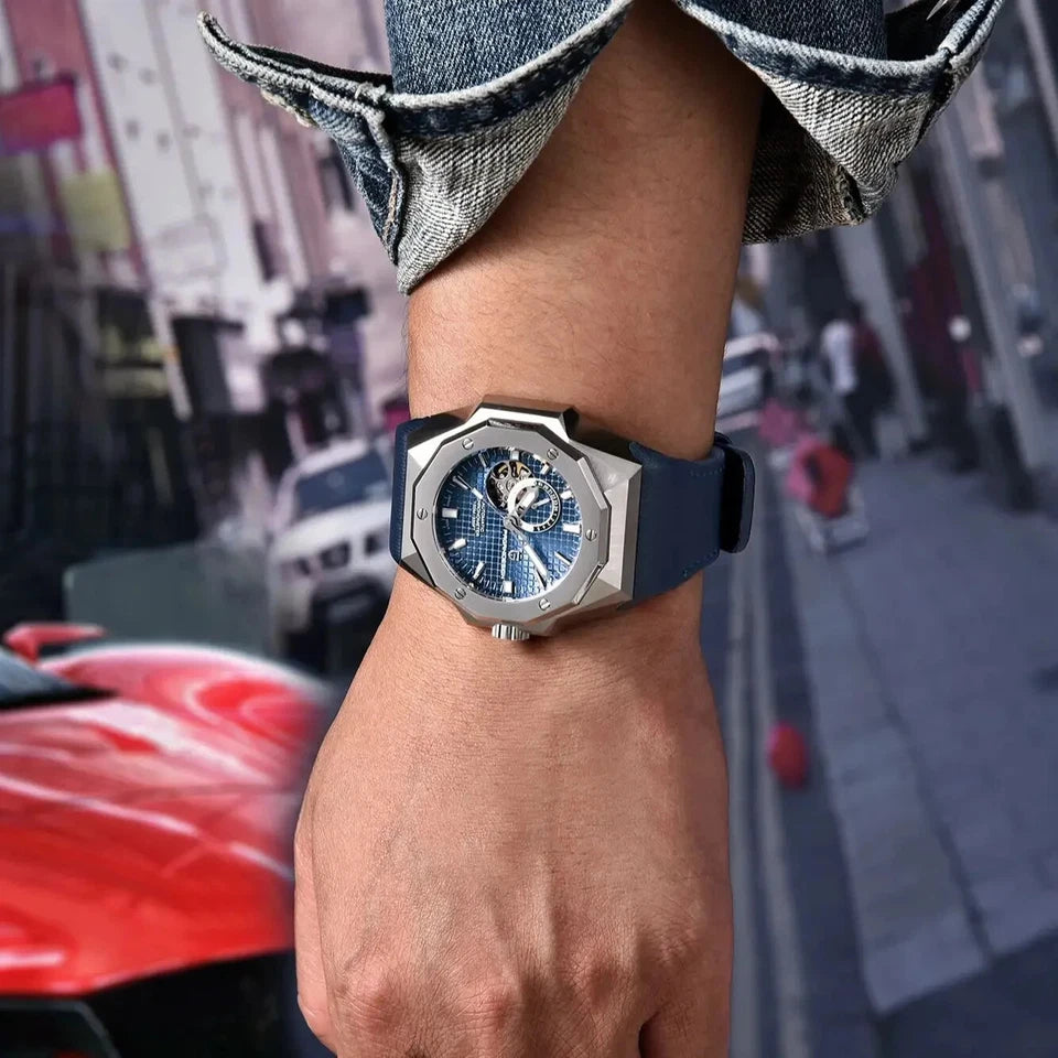 Wrist wearing a blue and silver watch with a city street in the background